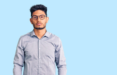 Handsome latin american young man wearing business clothes and glasses with serious expression on...