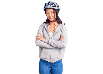 Young beautiful chinese girl wearing bike helmet happy face smiling with crossed arms looking at the camera. positive person.