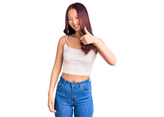 Fototapeta premium Young beautiful chinese girl wearing casual clothes doing happy thumbs up gesture with hand. approving expression looking at the camera showing success.