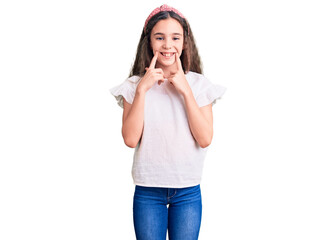 Cute hispanic child girl wearing casual white tshirt smiling with open mouth, fingers pointing and forcing cheerful smile