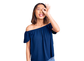 Fototapeta premium Young beautiful chinese girl wearing casual clothes doing ok gesture with hand smiling, eye looking through fingers with happy face.