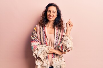 Young beautiful hispanic woman wearing casual clothes smiling happy pointing with hand and finger to the side