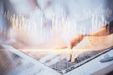 Double exposure of woman hands typing on computer and forex chart hologram drawing. Stock market...