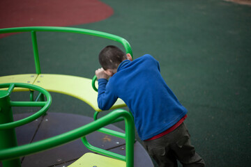 The child spins the carousel. Boy in the playground. 
