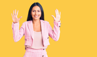 Young beautiful latin girl wearing business clothes showing and pointing up with fingers number ten while smiling confident and happy.