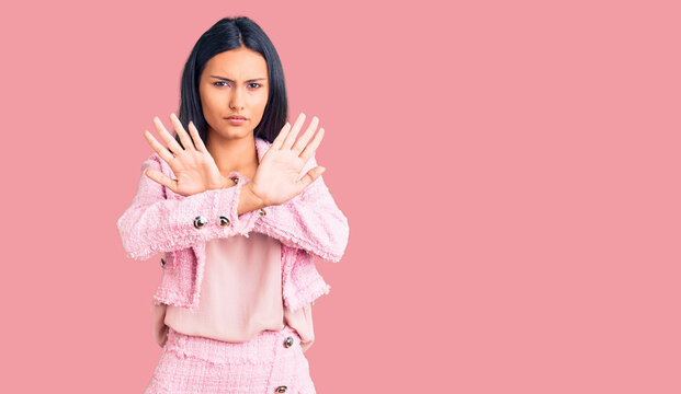 Young beautiful latin girl wearing business clothes rejection expression crossing arms doing negative sign, angry face