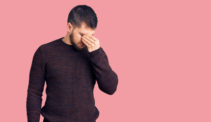 Young handsome man wearing casual sweater tired rubbing nose and eyes feeling fatigue and headache. stress and frustration concept.