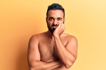 Fototapeta premium Young hispanic man standing shirtless thinking looking tired and bored with depression problems with crossed arms.