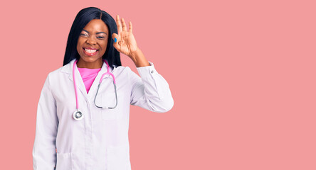Young african american woman wearing doctor stethoscope smiling positive doing ok sign with hand...