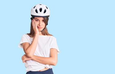 Young beautiful girl wearing bike helmet thinking looking tired and bored with depression problems with crossed arms.