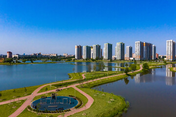 Obraz premium Panorama of the modern city. Residential building next to the ponds. Urban infrastructure. Recreation and sports areas in the city. Life in a modern city.