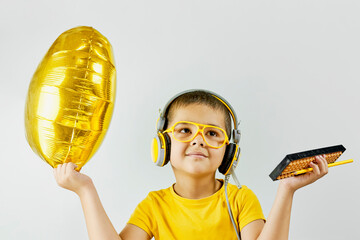 A kid celebrating the end of mental arithmetic courses. Portrait of a happy schoolboy in yellow