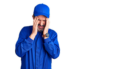 Middle age handsome man wearing mechanic uniform with hand on head, headache because stress....