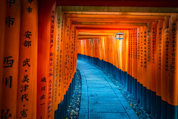 Fototapeta premium Japan. Kyoto. Inside the gate of Fushimi Inari temple. Fushimi Inari Taisha temple. The passage to the orange gate on mount Inariyama. The temple of the thousand gates. Torii with inscriptions.