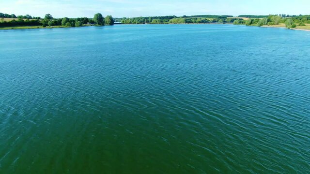 Low flight with a drone (DJI mavic 2 Zoom) over Pitsford Reservoir located in the UK. this stunning clip was recorded in 4k resolution at 30 frames per second. would be suitable for an opening visual.