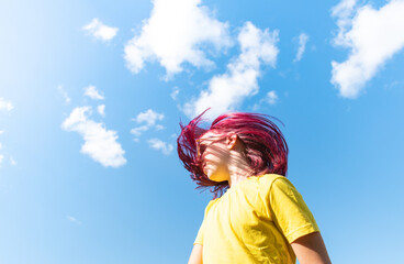 Attractive young girl with pink hair is dancing.