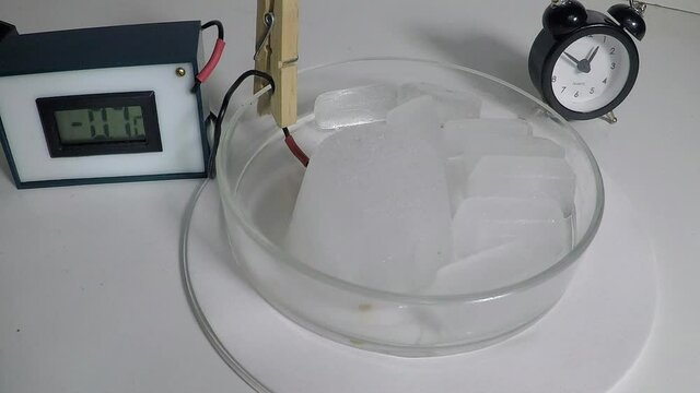 Timelapse of thawing ice with temperature measurement during the thaw. Notice how the temperature stops rising around 0&deg;C until all ice has gone.