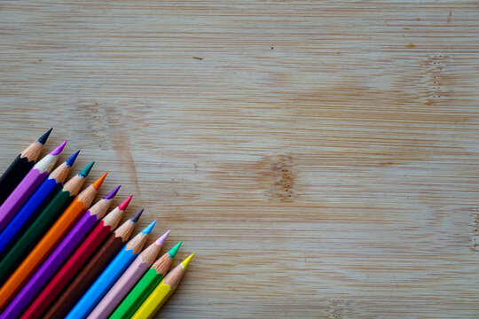 Arrange of pencils color and some origami paper with rustic wooden background. Back to school concept