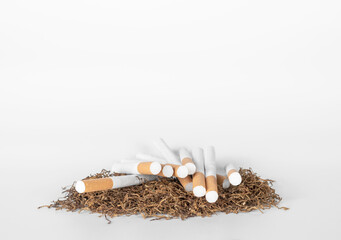 a lot of cigarettes on pile of tobacco lay on white background with copy space. concept for narcotic,illness.