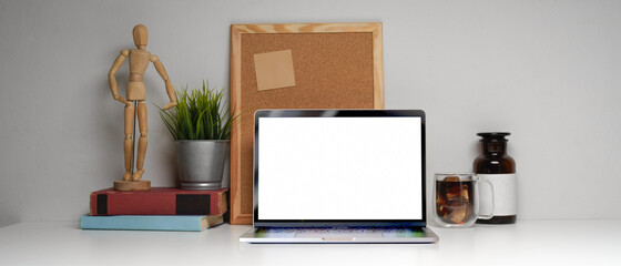 Home office desk with laptop, supplies, books, memory board and decorations, clipping path.