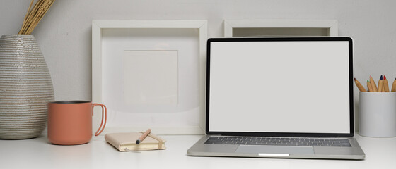 Home office desk with laptop, stationery and decorations on white table, clipping path.