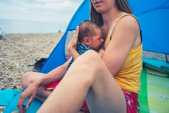 Young mother with baby in beach shelter