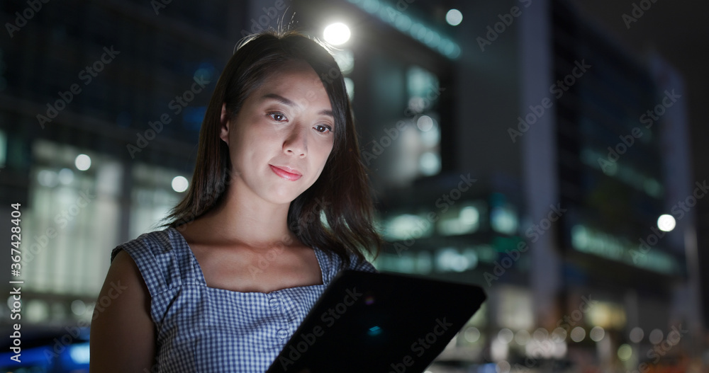 Poster Businesswoman work on tablet computer in city at night