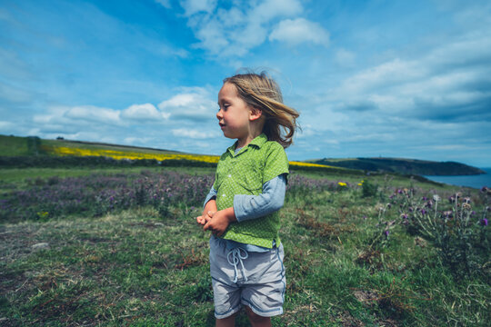 Preschooler boy standing on rocks in the countryside