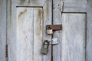 Old hanging rusty iron lock on wooden door