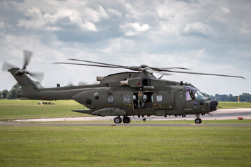 Plakat Large green army helicopter taxiing at an airbase after landing.