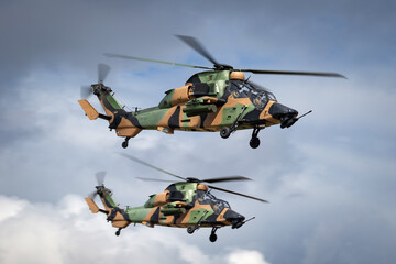 Fototapeta na wymiar Two Camouflaged army attack helicopters flying in formation.