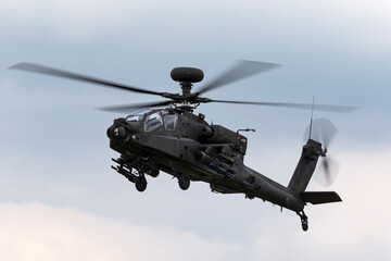 Naklejka na ściany i meble Army attack helicopter flying on an overcast day.