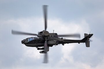 Army attack helicopter flying on an overcast day.