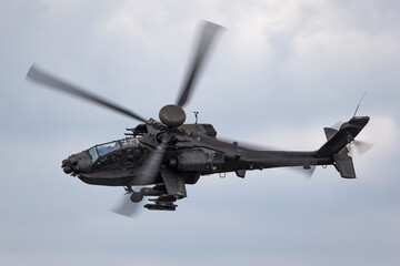 Army attack helicopter flying on an overcast day.