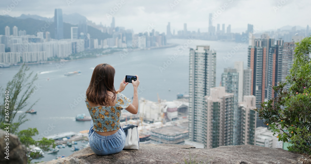 Sticker Woman sit on the rock and use of smart phone in city