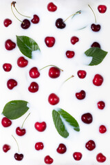 Ripe red fruits and cherry leaves float in the milk bath. Place for logo or text. Self-care concept using natural products and cosmetics