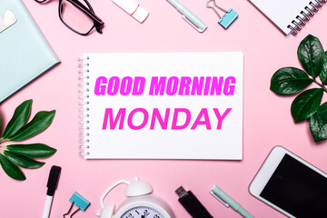 Fototapeta na wymiar Good morning monday written on pink background near stationery and green leaves. Motivational Concept
