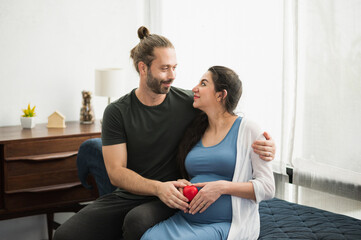 Handsome beard man take care his pregnant wife. Happy family concept.