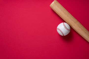 baseball and baseball bat on red table background, close up
