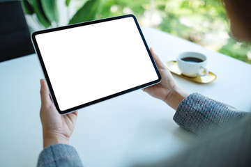 Mockup image of a woman holding tablet pc with blank white desktop screen in the office