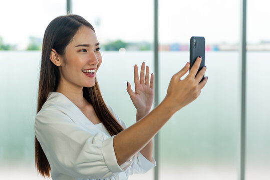 Young Asian Woman Greeting On Mobile Phone With Video Call.