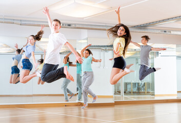 Group of young dancers jumping together in dance class