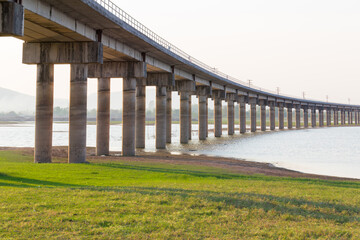 Rail way bridge cross over the dam with morning sky.