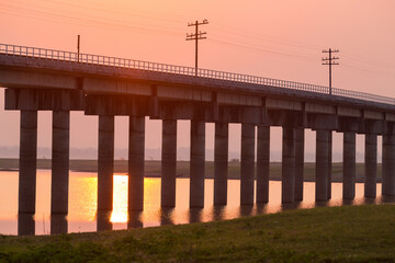 Rail way bridge cross over the dam with morning sky.