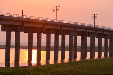 Rail way bridge cross over the dam with morning sky.