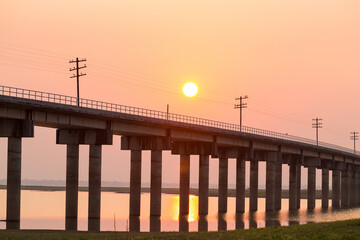 Rail way bridge cross over the dam with morning sky.