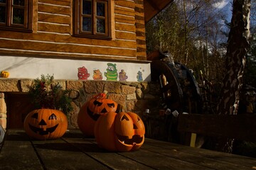 Three spooky-looking pumpkins in the gloom on the table for both scare and amusement, Halloween...