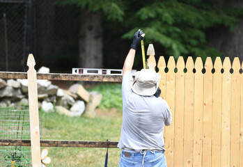 manual worker installing the wood fence in the yard