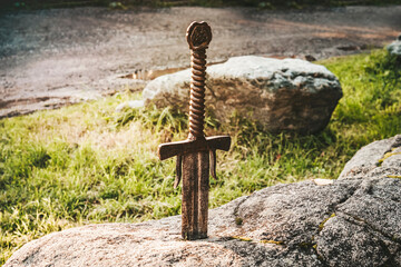 famous sword excalibur of King Arthur stuck in rock. Edged weapons from the legend Pro king Arthur.
