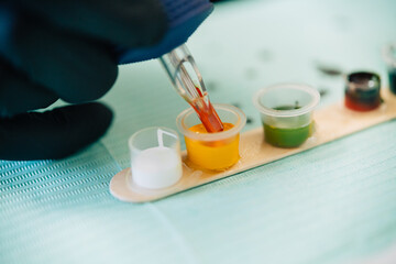 Tattoo woman loading the tattoo machine with ink.